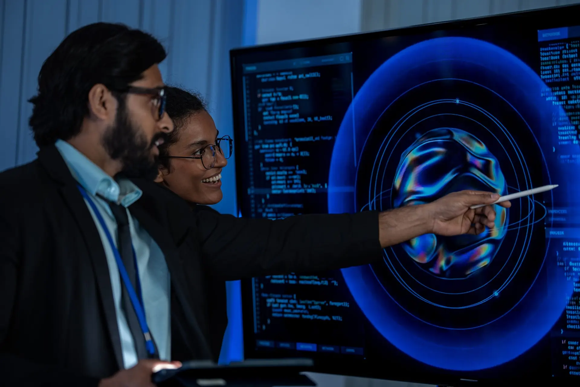 Two people work together at a large glowing display, designing software